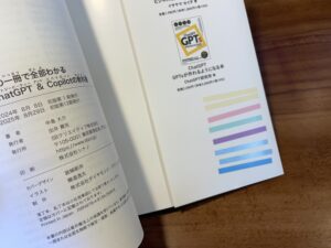 本の裏表紙の内側に、極細フィルム付箋の束を直接貼り付けている様子。ペンケースを使わない勉強ハック。