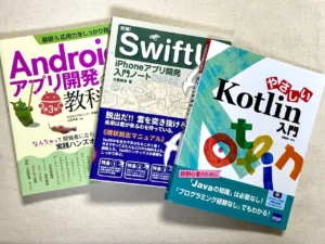 テーブルの上に積まれたAndroidやiOSアプリ開発のプログラミング書籍。50代の元プログラマーがここ数年で購入した技術書。