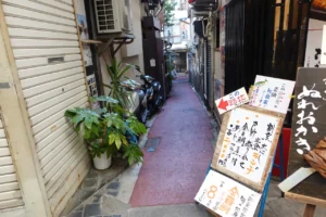 熱海の細い路地裏。古い定食屋の看板が見える風景。